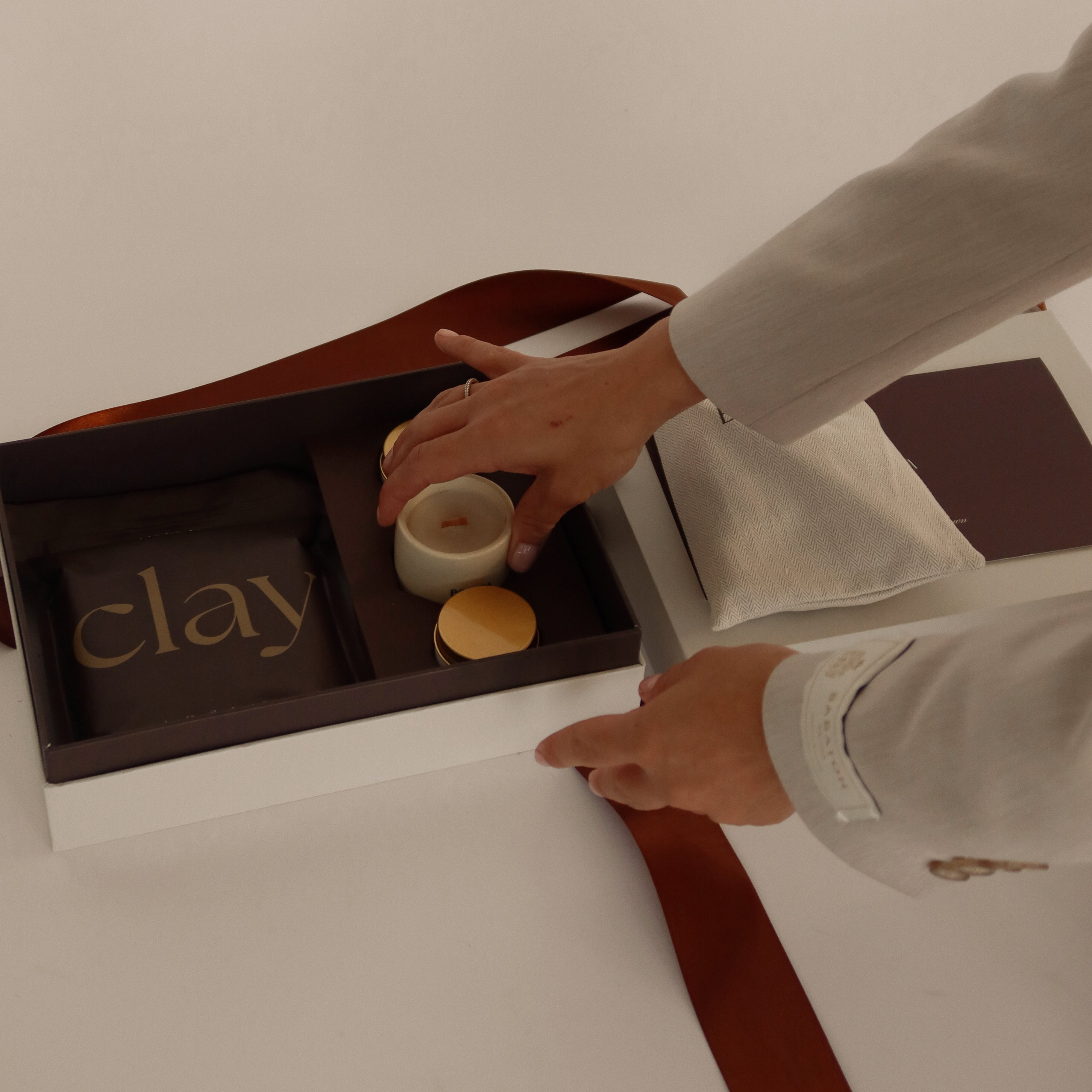 Beleza Pottery kit being opened and revealed displaying the contents (clay bag, candles, etc).