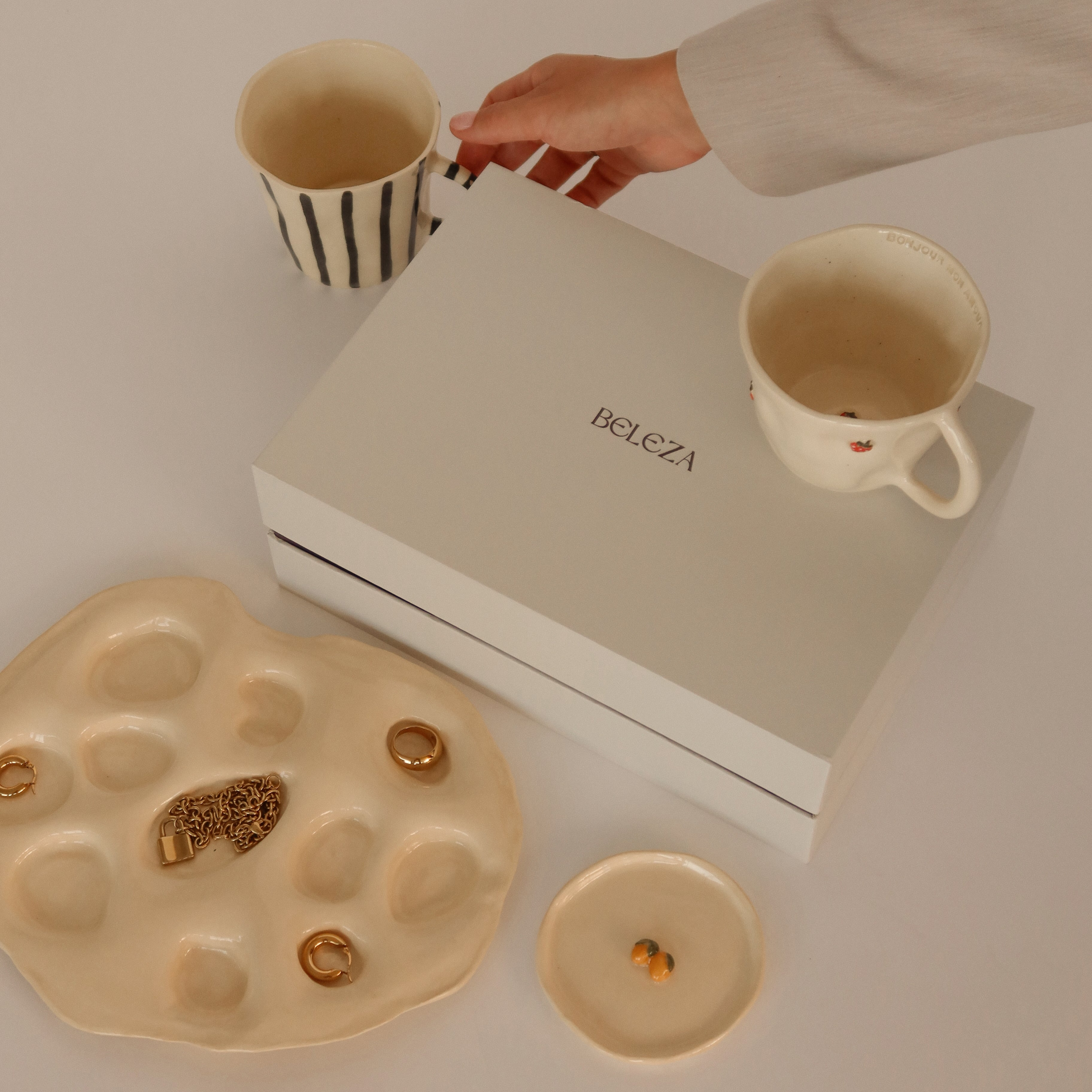 Beleza kit box displayed with 3 handmade mugs and 2 dishes for ceramic inspiration.