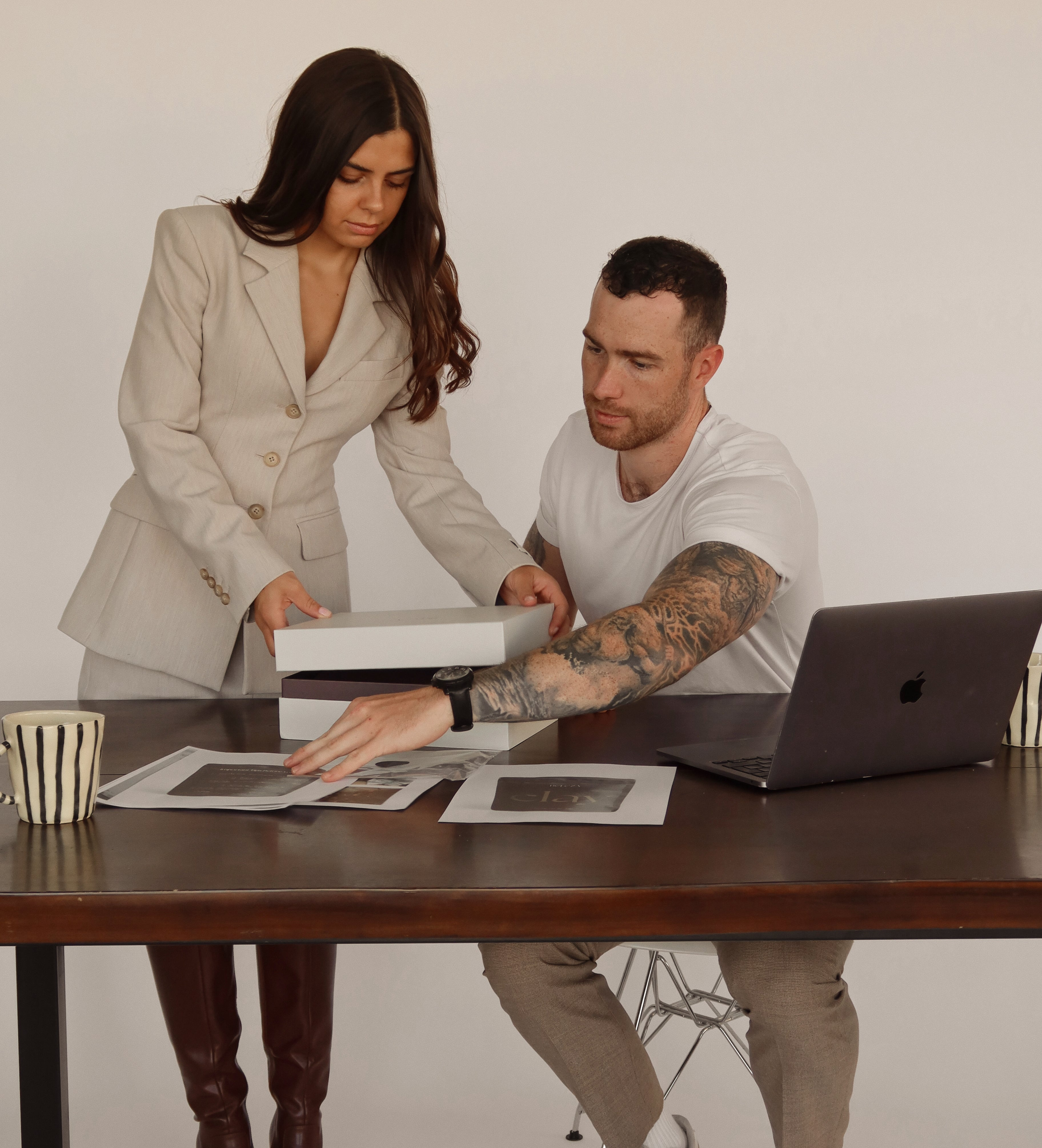 Beleza Founders (Calista & Josh) planning the pottery kit on a table with documents.